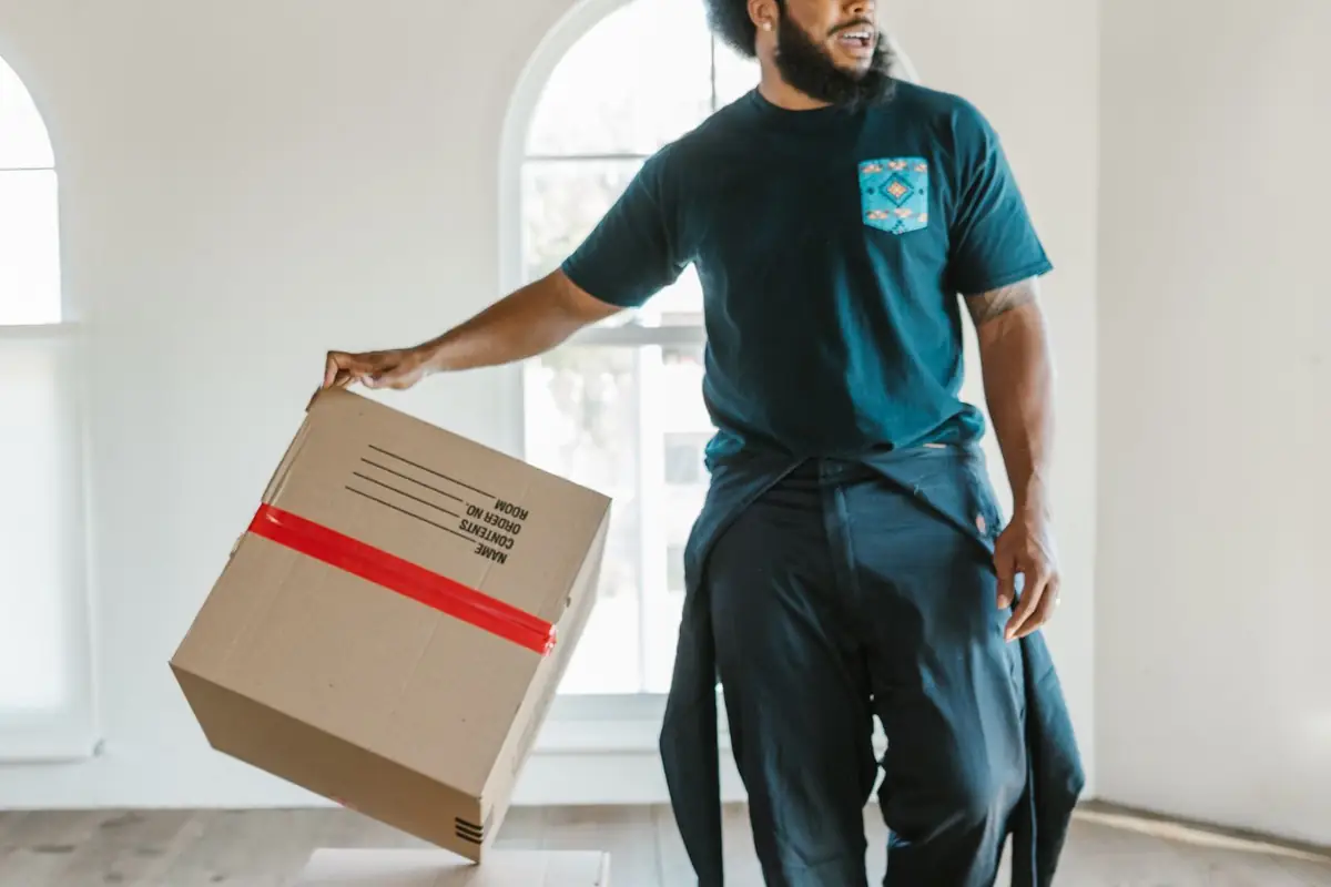 Déménageur évacuant un carton lors d'un débarras de logement